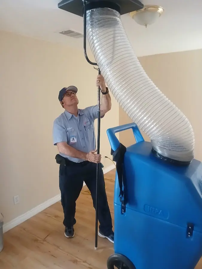 Furnace Tune-Up technician using HEPA equipment in Clay